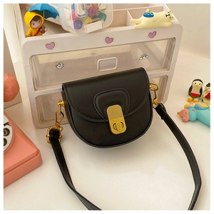 Detail view of a black saddle bag featuring a textured leather finish and golden metal clasp