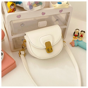 Close-up of white PU leather saddle bag featuring a vintage golden rotating lock