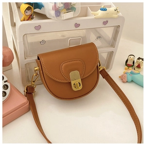 Close-up of brown saddle crossbody bag with a golden metal twist lock and fine stitching