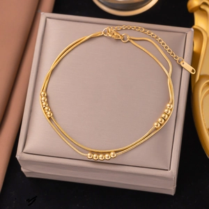 Detailansicht einer zweilagigen goldenen Schlangenkette mit beweglichen Perlen auf Schmuckbox