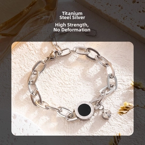 Detailed macro view of a silver titanium steel chain bracelet with Roman numeral pendant