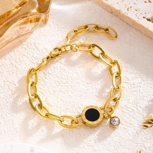 Gold chain bracelet featuring a black Roman numeral pendant and a small sparkling crystal