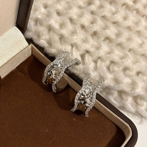 Modern wavy silver-toned hoop earrings with hammered metal texture and pave zircon edges