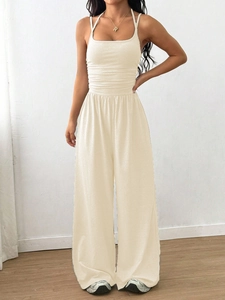 Detail of waist pleats on off-white halter neck jumpsuit with high waist wide-leg design