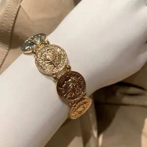 Bracciale elastico vintage oro chiaro con rilievi di monete in stile bohémien