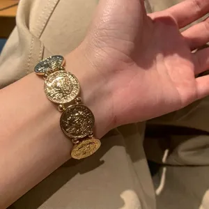 Bracciale elastico vintage in oro chiaro con monete a rilievo e stile bohémien