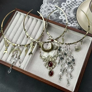Three vintage bohemian bronze chokers with tassels and ruby on grey velvet tray