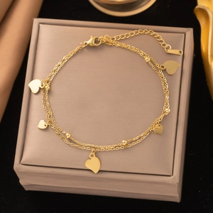 Double-layered gold titanium steel anklet with heart pendants on a velvet box