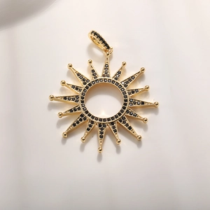 Detail view of 16-point sunburst gold pendant with micro-pave black cubic zirconia