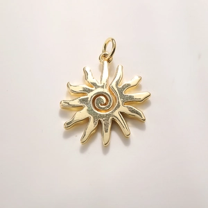 Detail of gold-plated sun charm with spiral texture and loop for jewelry making