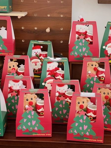 Close-up of Christmas gift box set with plush snowman and Santa ceramic mug inside