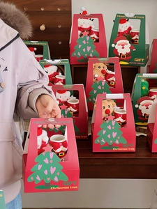 Close-up of Christmas gift box set with ceramic Santa mug and plush toy hanger