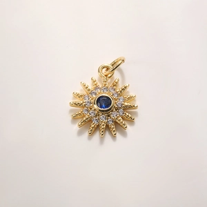 Detail of 18K gold starburst pendant with blue center stone and pave crystals