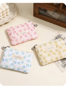 Detailed view of floral lace makeup pouches in pink, blue, and yellow with flower zippers
