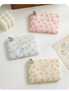 Detail of floral lace coin purses with flower zipper pulls and woven brand labels