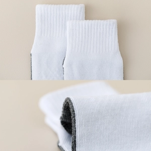 Detail of high-elastic ribbed cuffs and high-density knit texture on white cotton baby socks