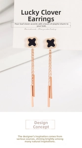 Detail of rose gold clover drop earrings with black enamel and dangling chain bars