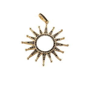 Gold sun pendant with black zircon inlays and radiant rays on a white background
