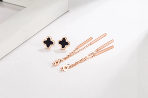 Close-up of S925 silver stamp on rose gold clover stud earrings with black inlay