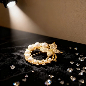 Close-up of golden butterfly pearl brooch with sparkling crystals on black velvet