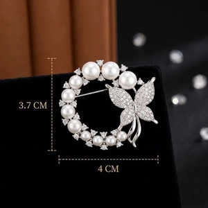 Elegant butterfly and pearl brooch with zircon accents on a black velvet base, 4x3.7cm