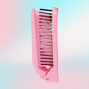 Close-up of pink portable folding comb featuring dual black teeth for hair styling