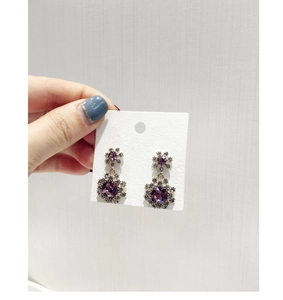 Vue détaillée des boucles d'oreilles flocon vintage avec cristal violet et pavage
