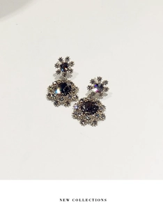 Détail de boucles d'oreilles flocon de neige avec pierre grise et halo de cristaux