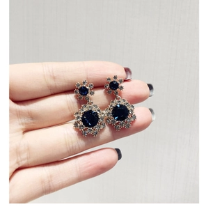 Vue macro de boucles d'oreilles vintage avec cristaux bleu foncé et strass brillants