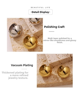 Detailed macro of high-polished gold and silver hollow sphere earrings on stone