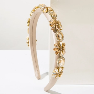 Macro detail of luxury baroque headband with champagne crystals and satin fabric