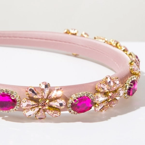 Macro detail of luxury pink satin headband with multi-color rhinestones and floral gems