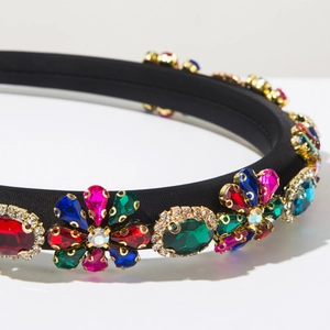 Close-up of luxury Baroque headband with colorful crystals on black satin fabric
