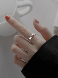 Dettaglio di un anello in argento 925 minimalista con una sottile linea nera sul dito