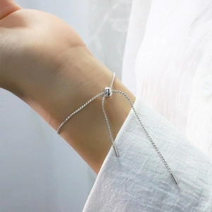 Detail of adjustable silver beaded bracelet featuring a sliding clasp on model wrist