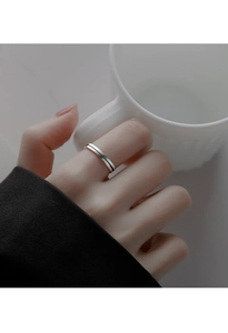 Dettaglio di un anello a righe minimalista in argento s925 indossato con una tazza bianca