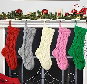 Detail of five multi-colored knitted Christmas stockings with diamond cable pattern hanging