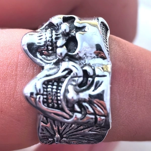 Close-up of gothic silver skull ring with intricate dual-face engraving and vintage texture