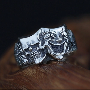 Retro Thai silver clown mask ring with gothic skull relief on dark wood background