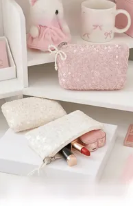 Detail of sequin coin purse with pearl zipper handle featuring pink and white colors