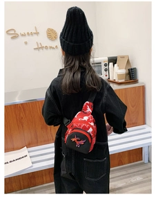Detailed back view of a red and black cartoon dinosaur chest bag for children