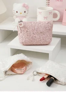 Detail of pink and white sequin coin purses with pearl bow zipper and lace texture