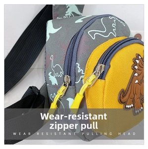 Close-up of durable cartoon dinosaur chest bag featuring smooth yellow rubber zipper pullers