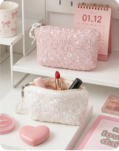Detail of pink and white sequin coin purses with decorative pearl zipper pulls