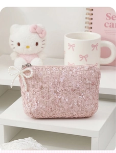 Detailed shot of pink sequin lace coin purse featuring a delicate pearl bow zipper pull