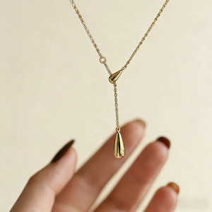 Detail view of a 18K gold-plated Y-shaped necklace featuring two elegant teardrop pendants