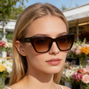 Detail of oversized cat eye sunglasses with brown gradient lenses on a male model