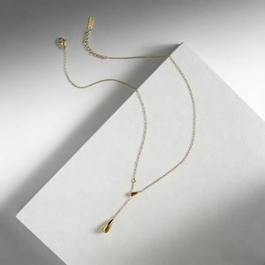Macro detail of gold-plated teardrop necklace with polished finish and S925 engraving