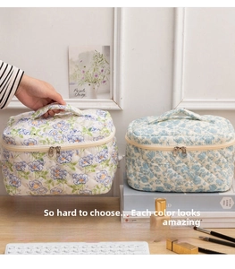 Detailed view of quilted cotton floral cosmetic bags with dual zipper and wide top handle