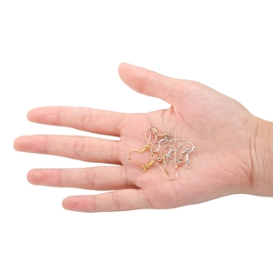 Hand holding silver, gold, and rose gold S925 fish hook earrings for size reference